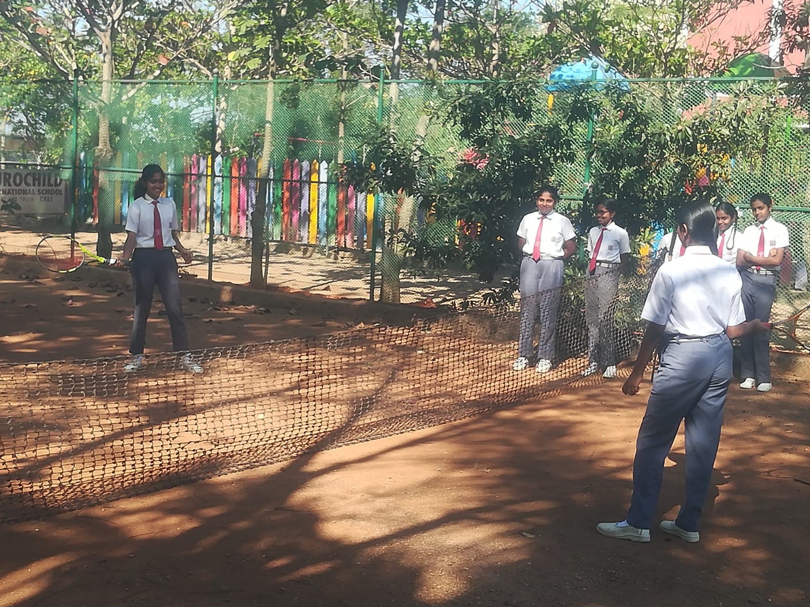 Students practicing on the Aurochild tennis court