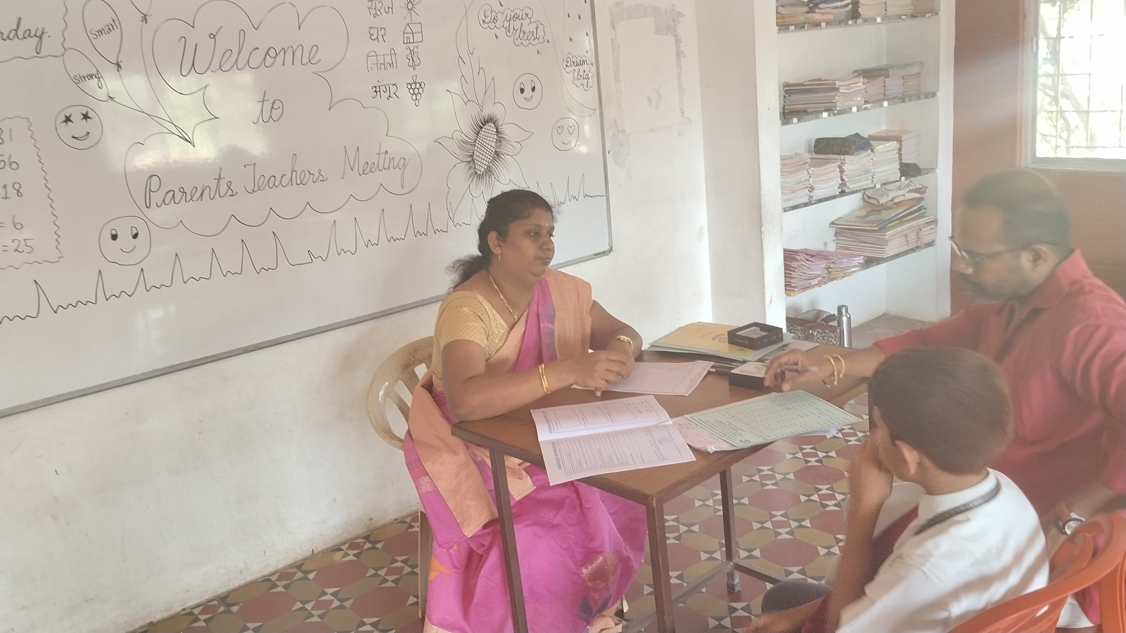 Parent-teacher discussion about student English communication progress at Aurochild