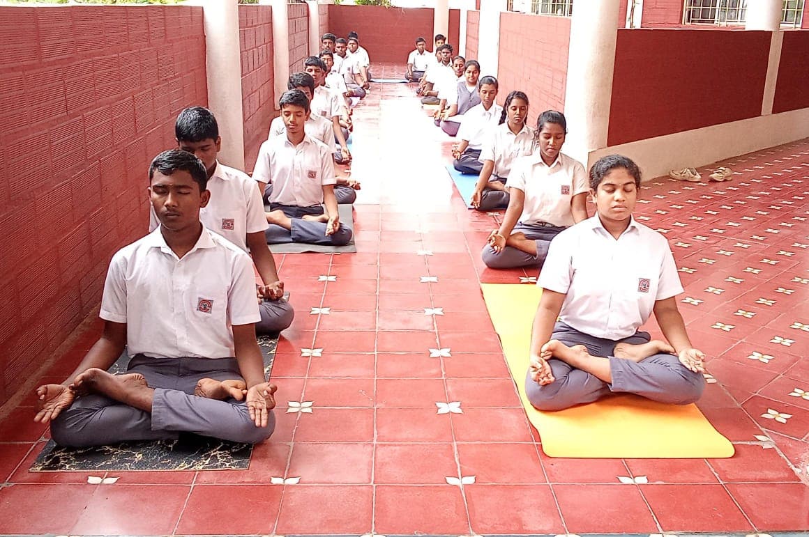 Aurochild students practising yoga in a calm campus corridor