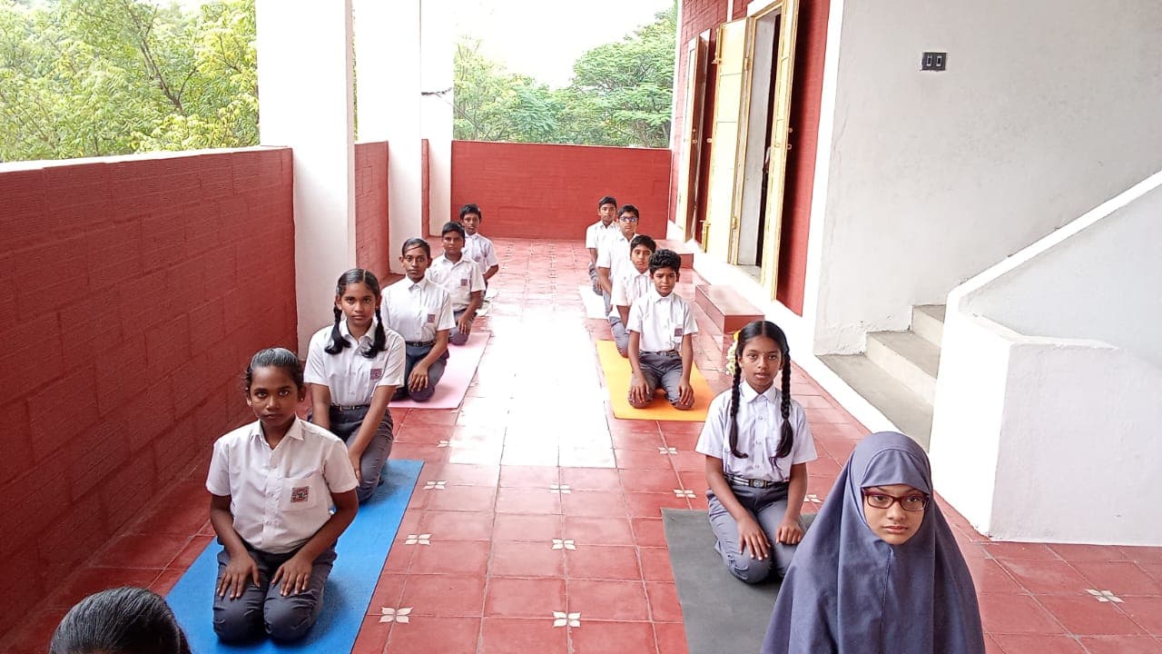 Students practising yoga in a school corridor