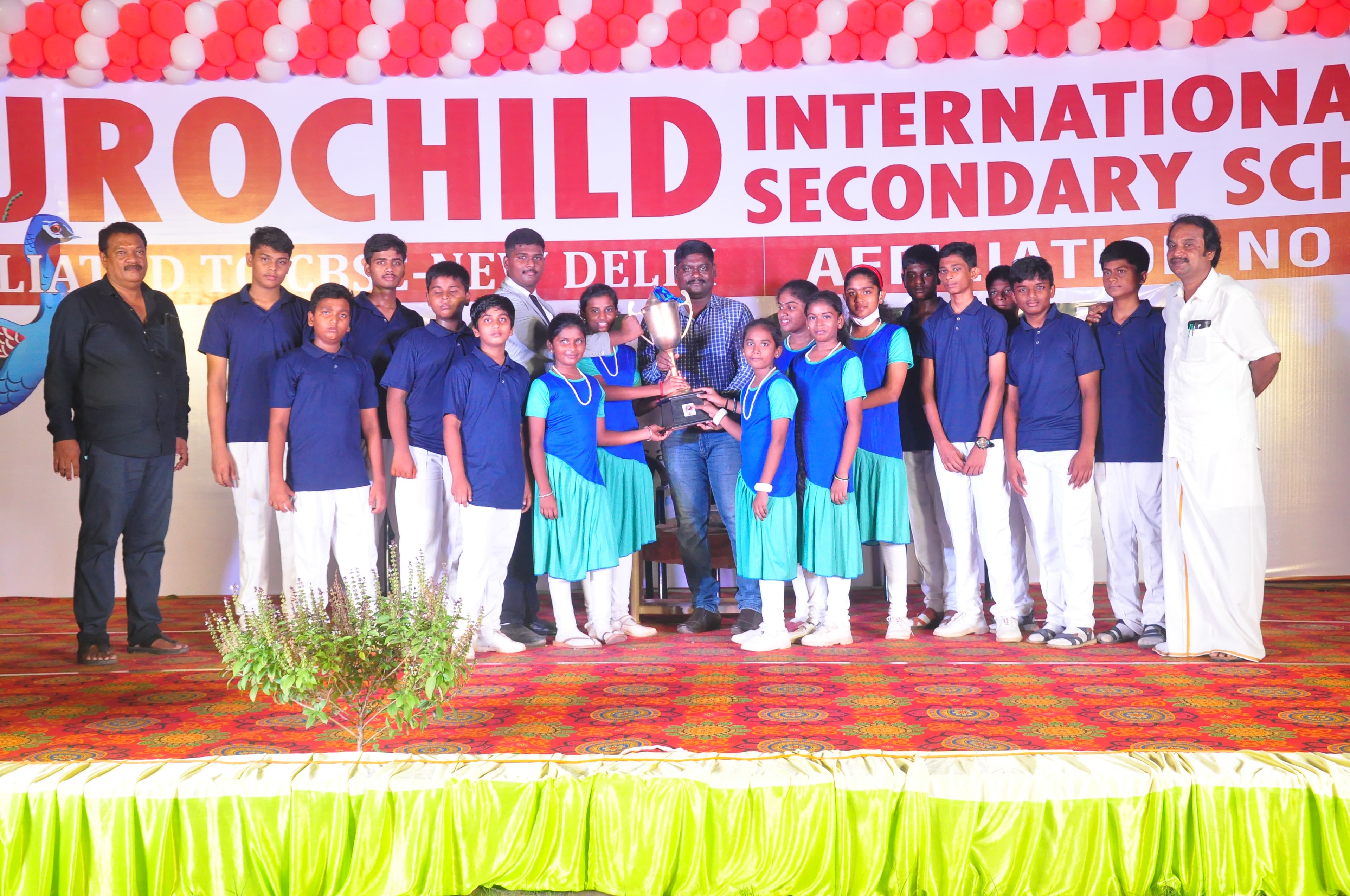 Students celebrating with a sports trophy